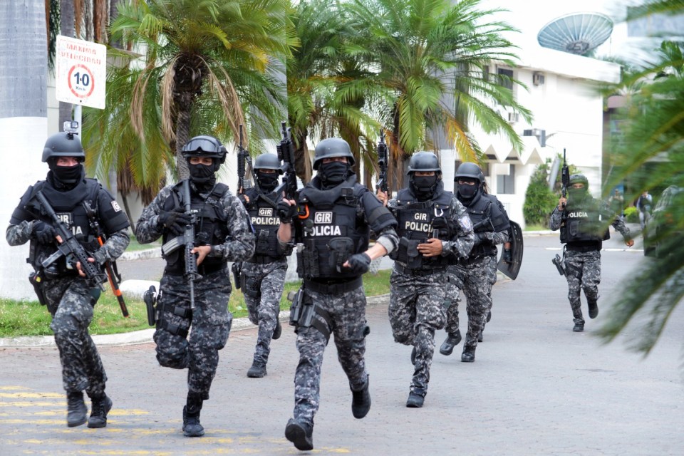 An Ecuadorean police squad enters the premises of Ecuador's TC television channel after unidentified gunmen burst into the state-owned television studio live on air on January 9, 2024, in Guayaquil, Ecuador, a day after Ecuadorean President Daniel Noboa declared a state of emergency following the escape from prison of a dangerous narco boss. Gunshots rang out on live TV in violence-torn Ecuador as armed men carrying rifles and grenades stormed the studio shortly after gangsters vowed a "war" against the president's plans to reclaim control from "narcoterrorists". (Photo by STRINGER / AFP) (Photo by STRINGER/AFP via Getty Images)
