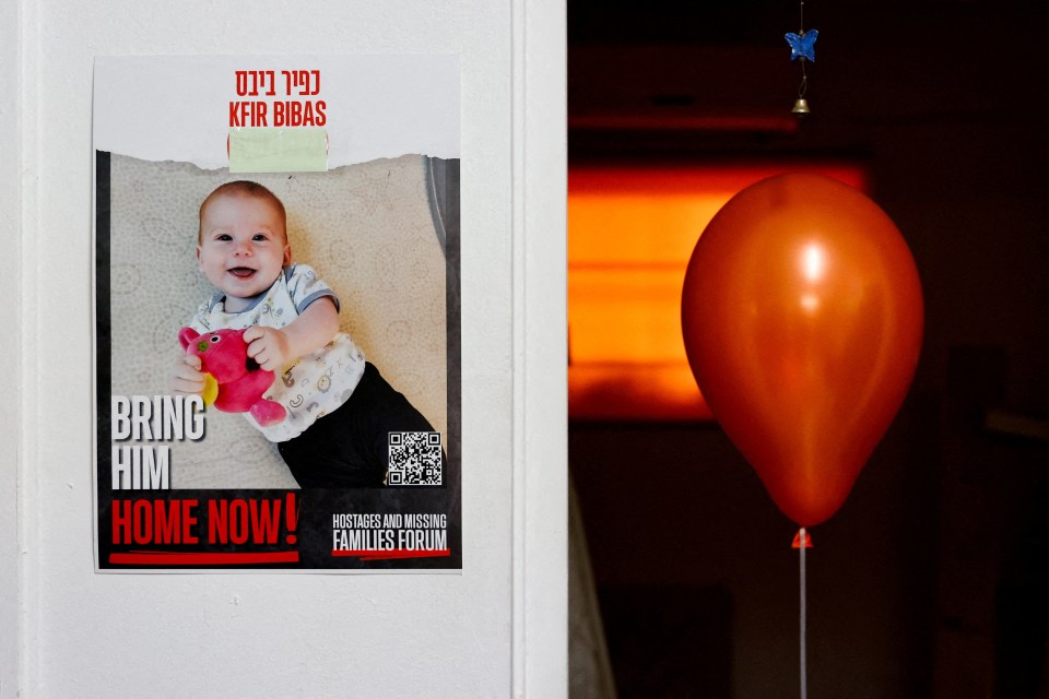 A poster calling for the release of hostage Kfir Bibas, next to an orange balloon.