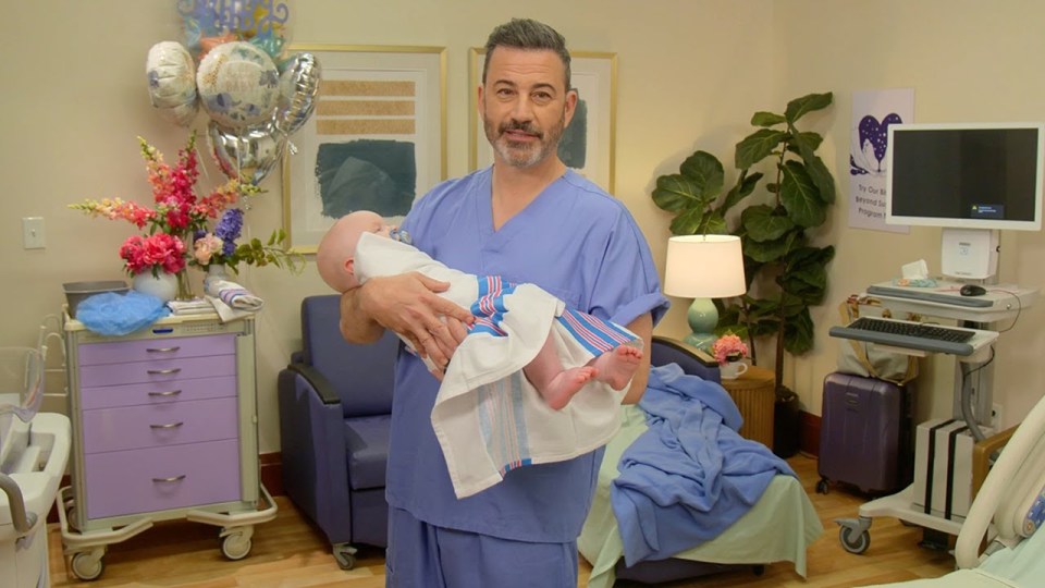 Jimmy Kimmel holding a newborn baby.