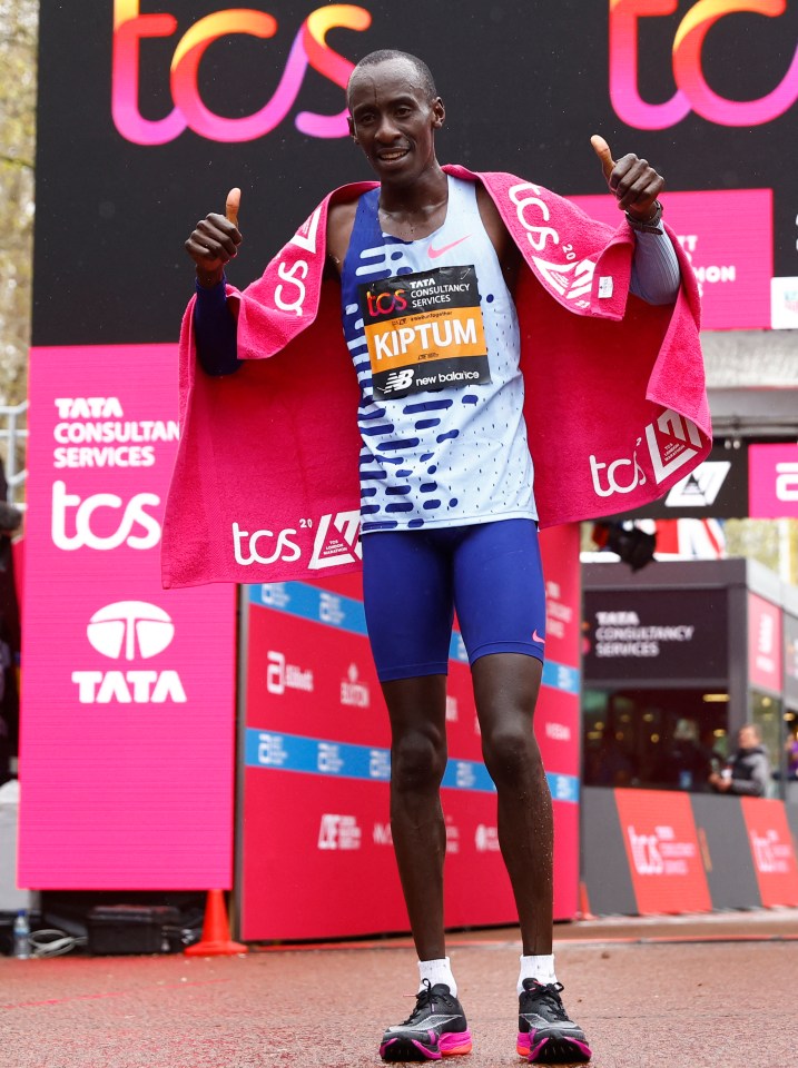 Kiptum poses as he celebrates winning the elite men’s race in just two hours and 35 seconds