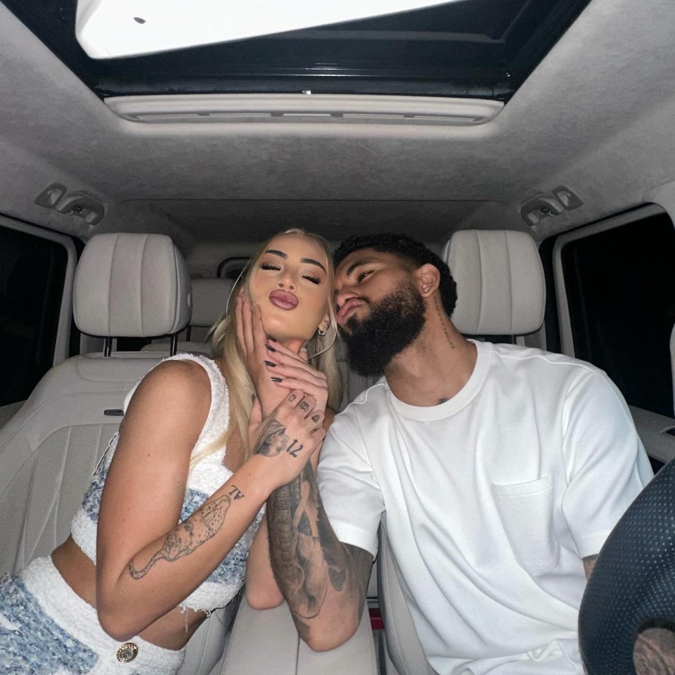 a man and a woman are kissing in the back of a car