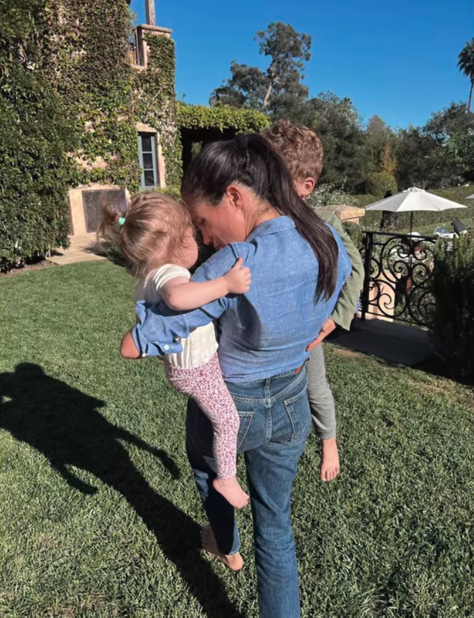 a woman is holding two children in her arms