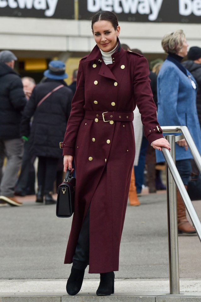 The TV presenter oozed style as she posed in a long maroon belted coat with gold buttons