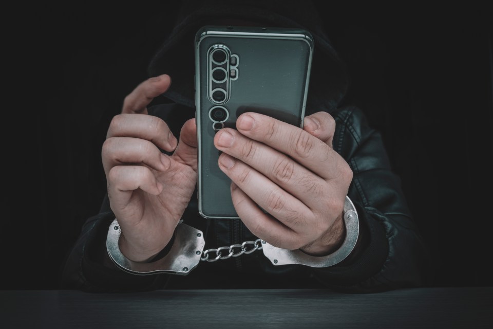 Handcuffed person using a smartphone.