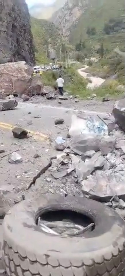 The wheel of one truck lying on the road with other crushed parts