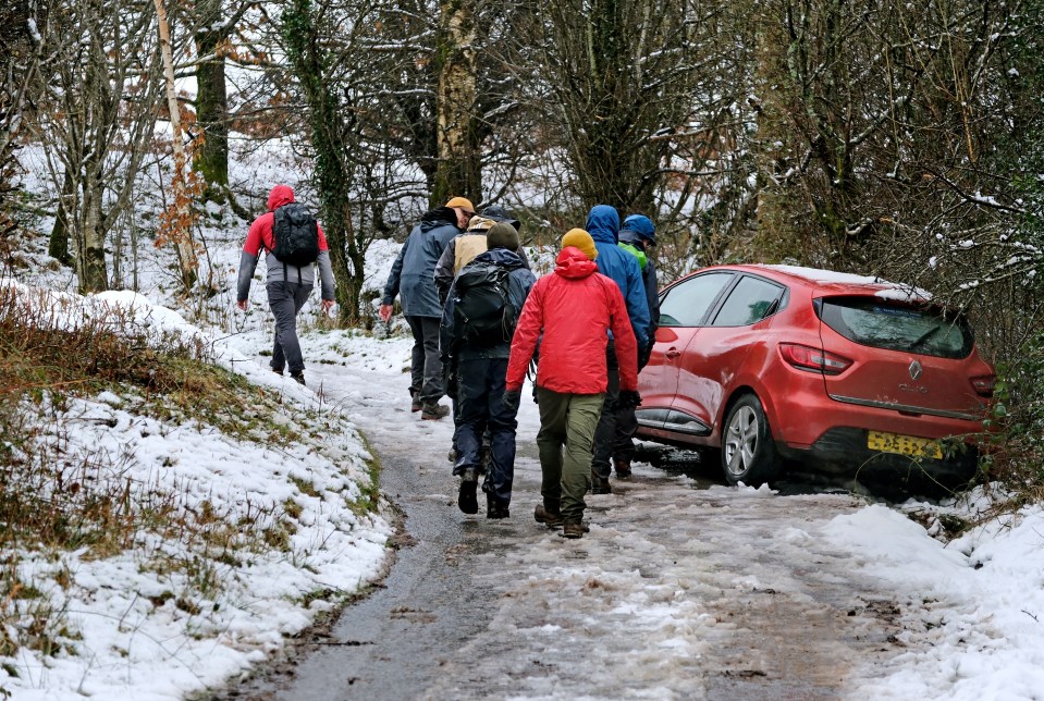 Walkers passed an abandoned car as heavy snow fell on the Black Hill in Southern Herefordshire the same day