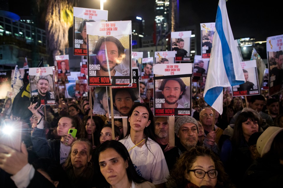 People hold photos of hostages during a rally in Tel Aviv, Israel