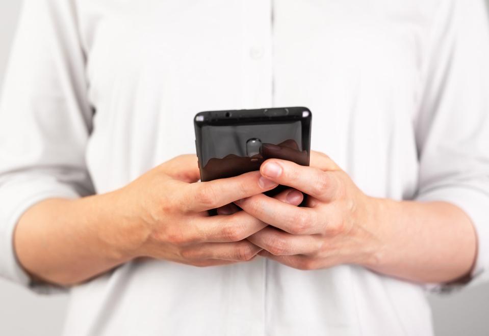 a person is holding a cell phone in their hands