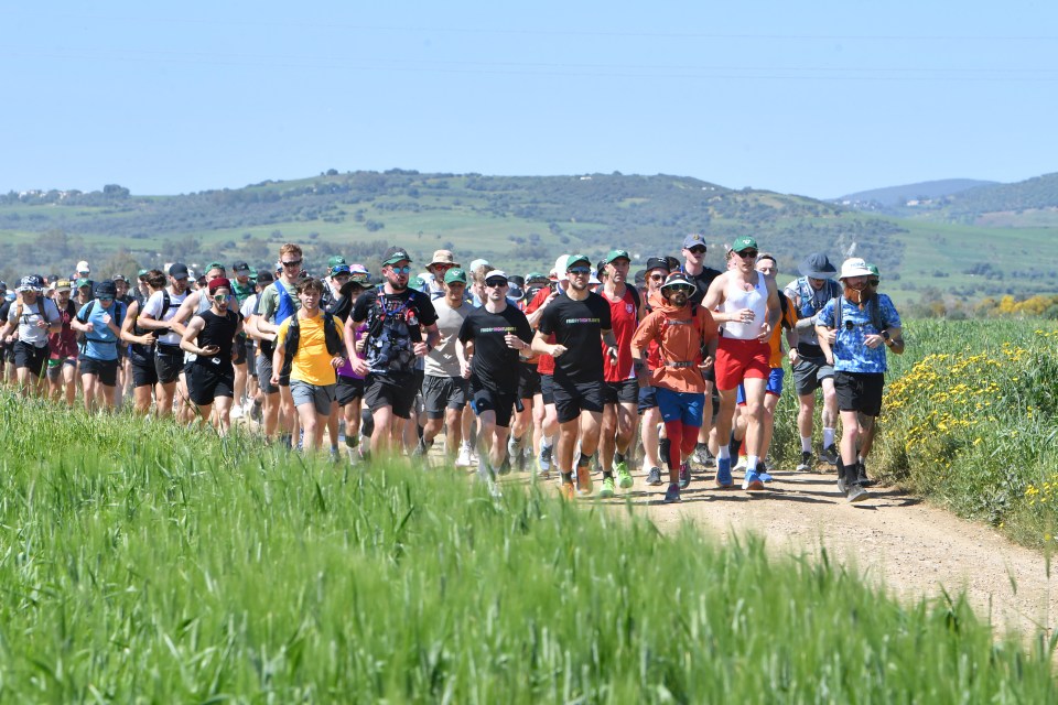 Britain's Russ Cook (R) runs, with supporters who joined him for the final leg of the 16,000km challenge to run the length of Africa from South Africa's Cape Agulhas to Tunisia's Cape Angela to raise money for charity, in town of Ghazela, north east of Tunis on April 7, 2024. (Photo by FETHI BELAID / AFP) (Photo by FETHI BELAID/AFP via Getty Images)