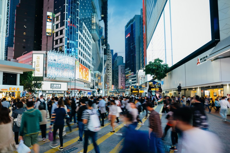 a busy city street with a mitsubishi sign in the background