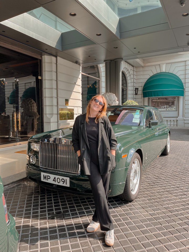 a woman stands in front of a green car with a license plate that says mp 4091