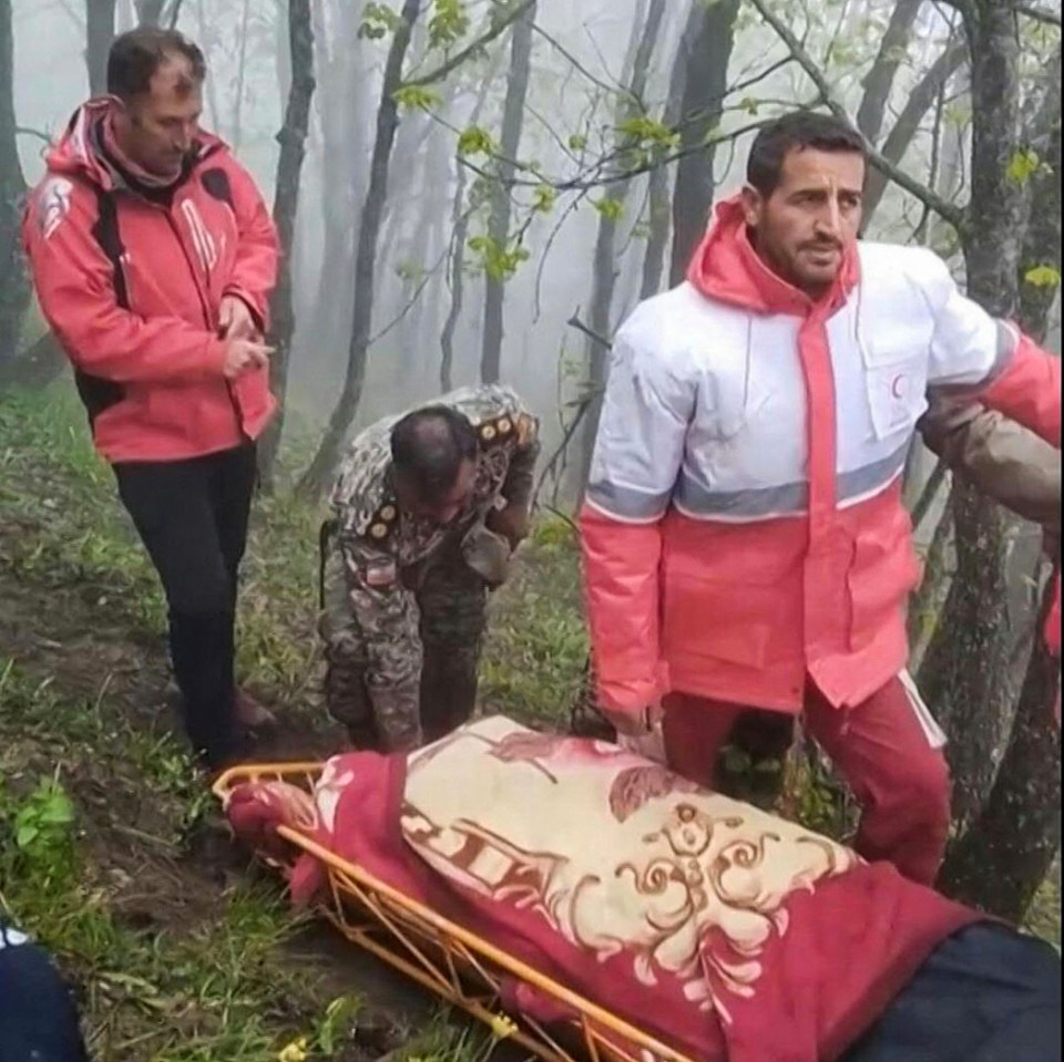 Rescuers recover bodies at the site of the helicopter crash