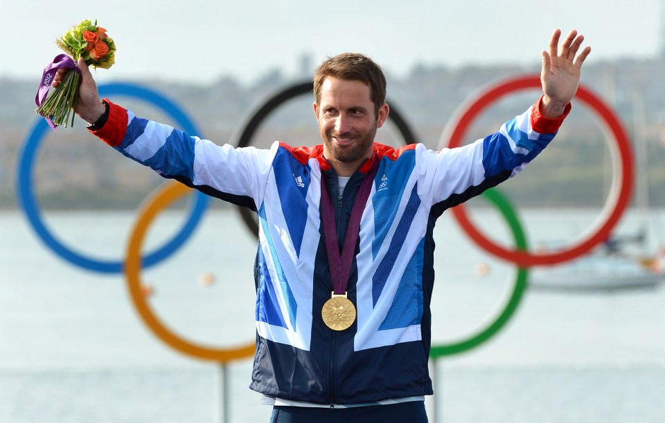 (FILES) - A picture dated August 5, 2012 shows Britain's Ben Ainslie acknowledging the applause on the podium after receiving the gold medal in the Finn sailing class at the London 2012 Olympic Games, in Weymouth. Ainslee is among a parade of Olympic champions whose achievements in a remarkable summer of sport in Britain were recognised in the New Year Honours list on December 29, 2012. AFP PHOTO/William WESTWILLIAM WEST/AFP/Getty Images