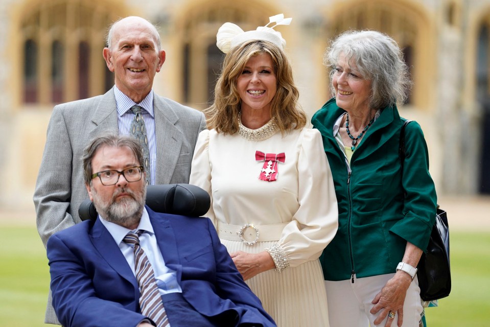 Kate with her parents and late husband Derek as she's awarded with an MBE