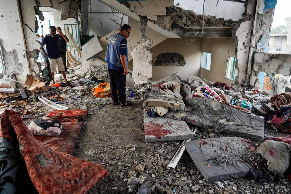 UN workers pick through the rubble at the school following an Israeli strike