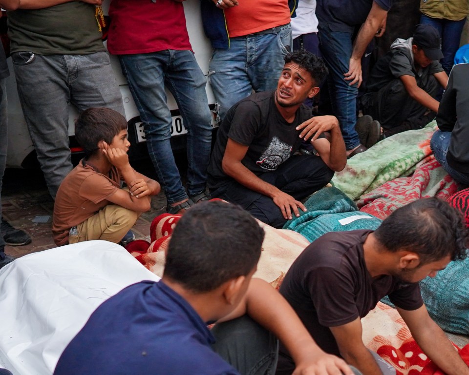 Gazans mourn those killed in the hit as victims lie in body bags on the ground