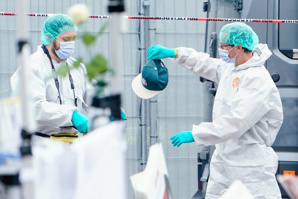 A forensic police officer work holds a cap at the scene of the attack on Friday