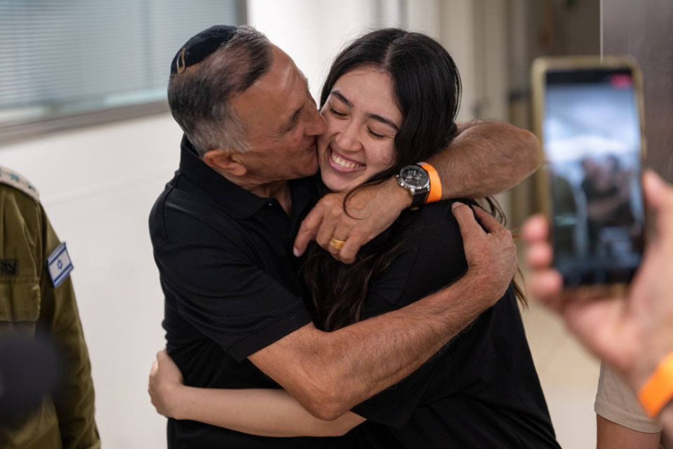 a man in a military uniform kisses a woman on the cheek
