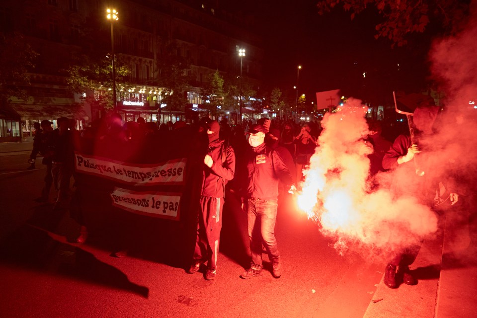 a man holding a sign that says plus que la vengeresse