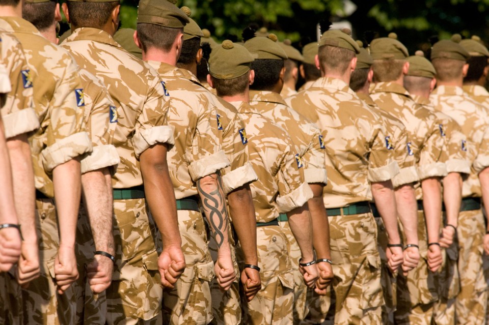 a group of soldiers standing in a line with the letter b on their uniforms