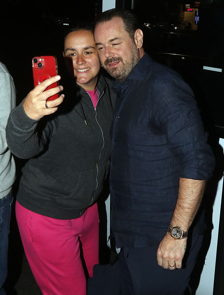 a man taking a selfie with a woman wearing pink sweatpants