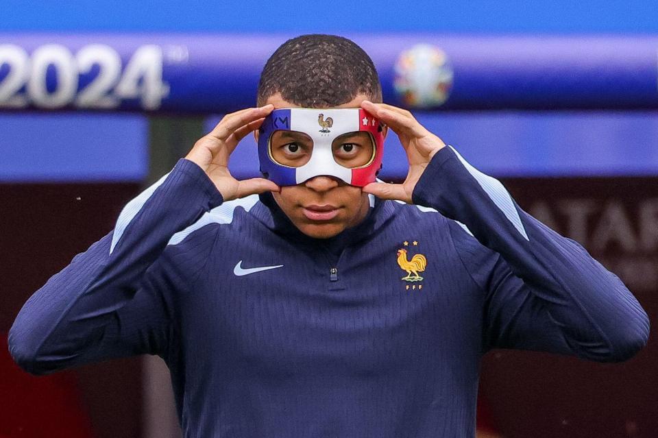 a man wearing a mask with the letter m on it