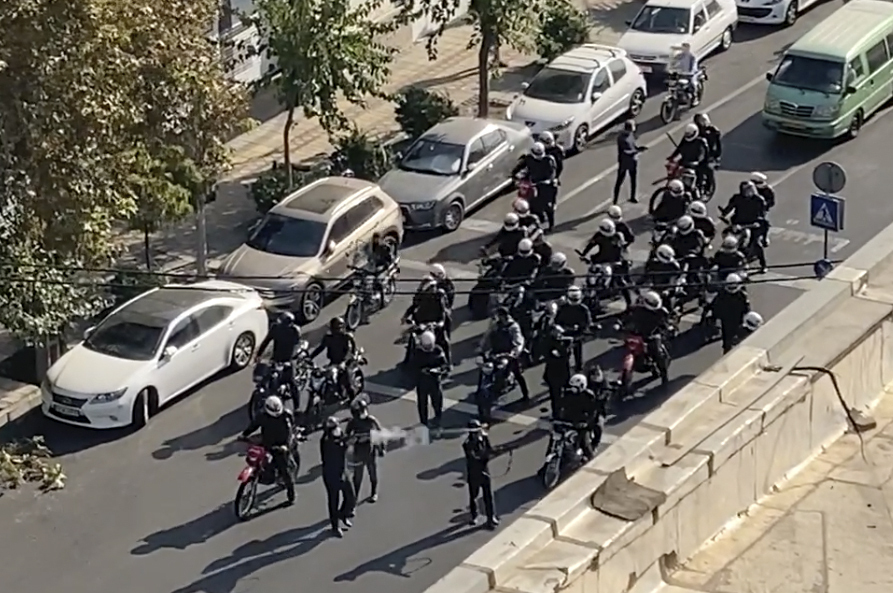 a group of police officers are riding motorcycles down a street