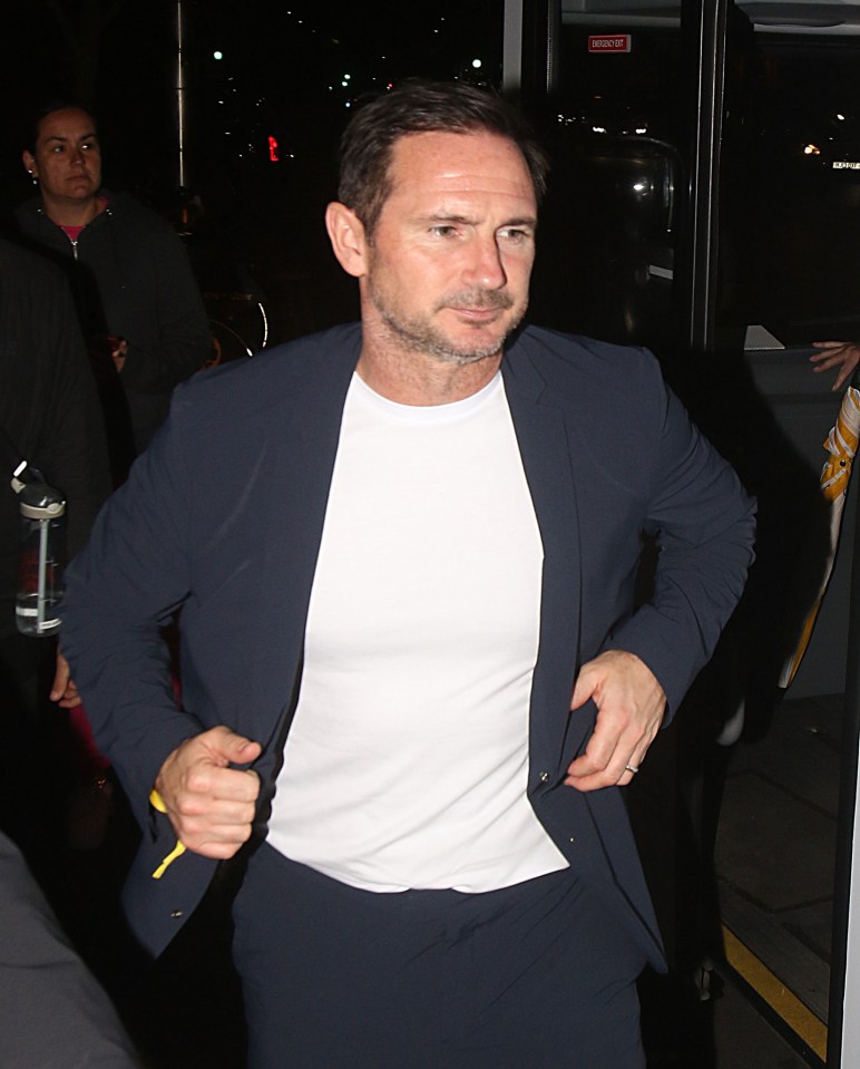 a man wearing a suit and a white t-shirt is standing in front of a sign that says emergency exit