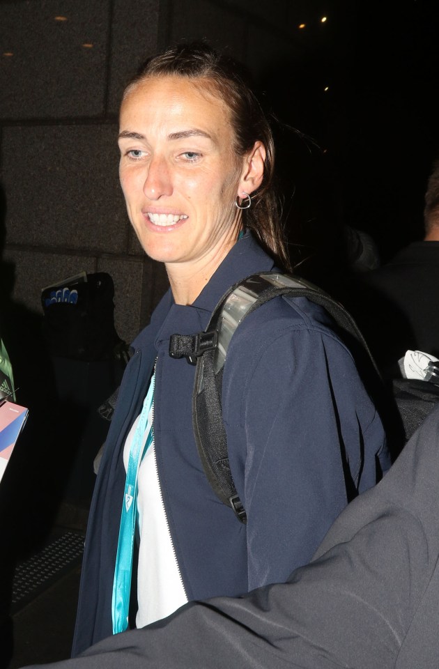 a woman wearing a blue jacket and a backpack smiles for the camera