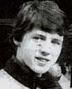 a black and white photo of a young man looking at the camera .