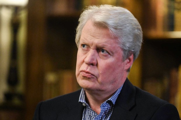 a man with gray hair is wearing a black suit