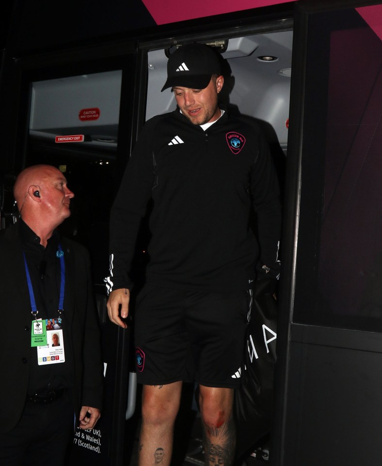 a man wearing a black adidas sweatshirt walks out of an emergency exit