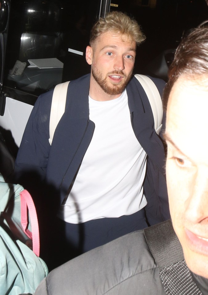 a man wearing a white shirt and a blue jacket has a sticker on his jacket that says ' emergency exit '