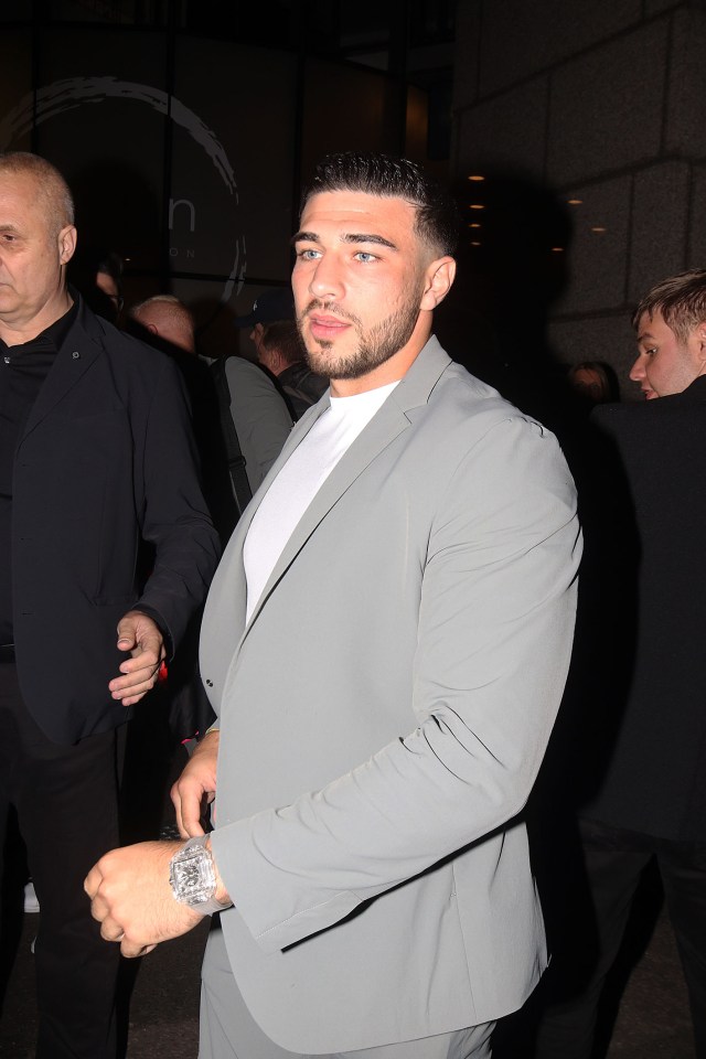 a man in a grey suit has a watch on his wrist