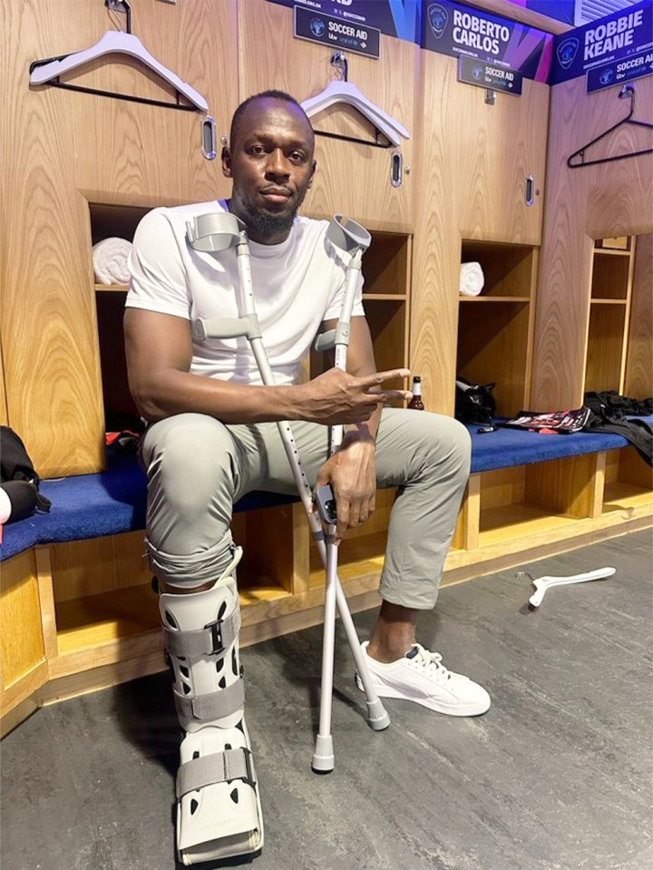 a man with crutches sits in a locker room with a sign that says robbie keane