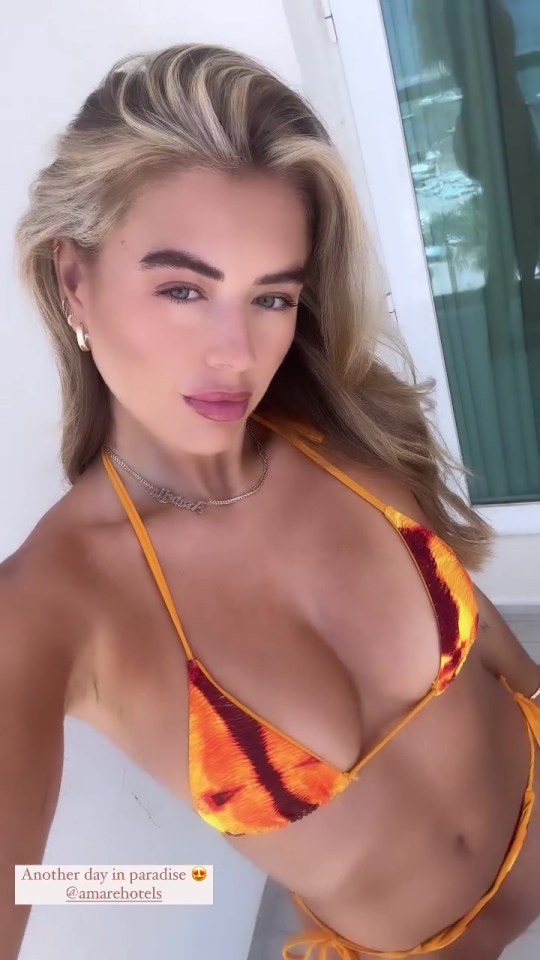 a woman in a bikini takes a selfie with the caption another day in paradise