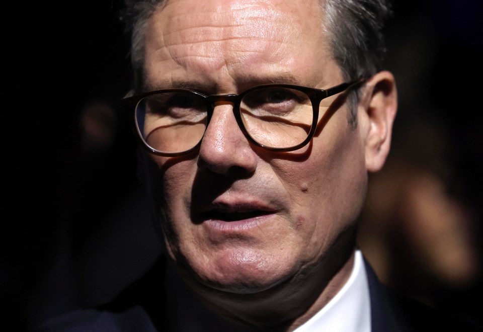 a close up of a man wearing glasses and a suit
