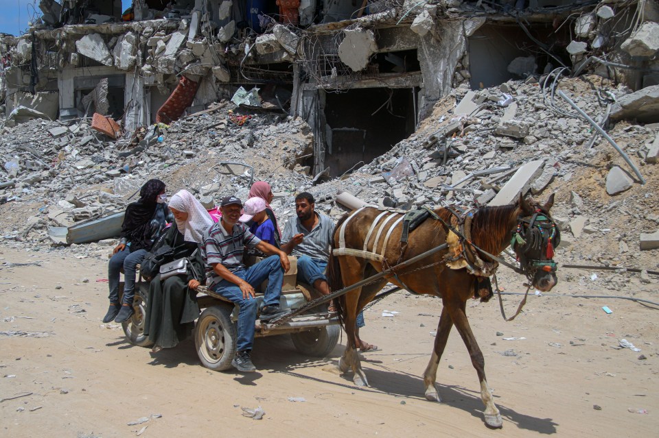 Palestinians in Khan Younis near a building destroyed by the Israeli Defence Force