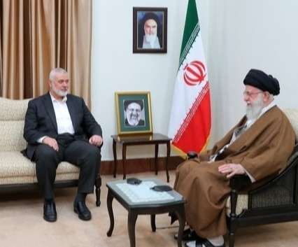 two men are sitting in front of an iranian flag