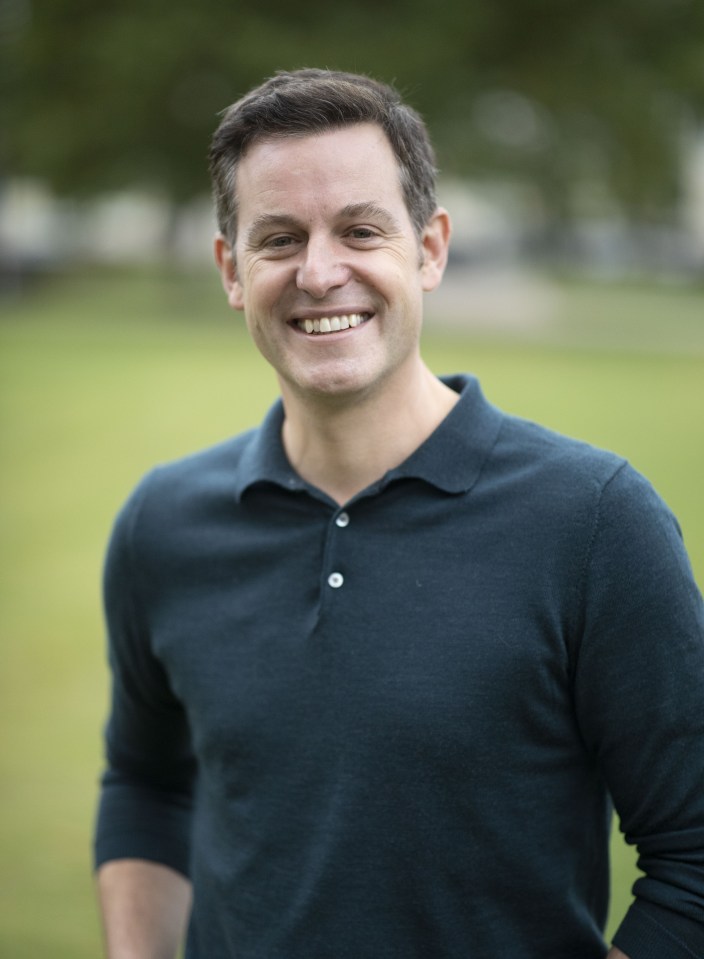 a man wearing a blue polo shirt smiles for the camera