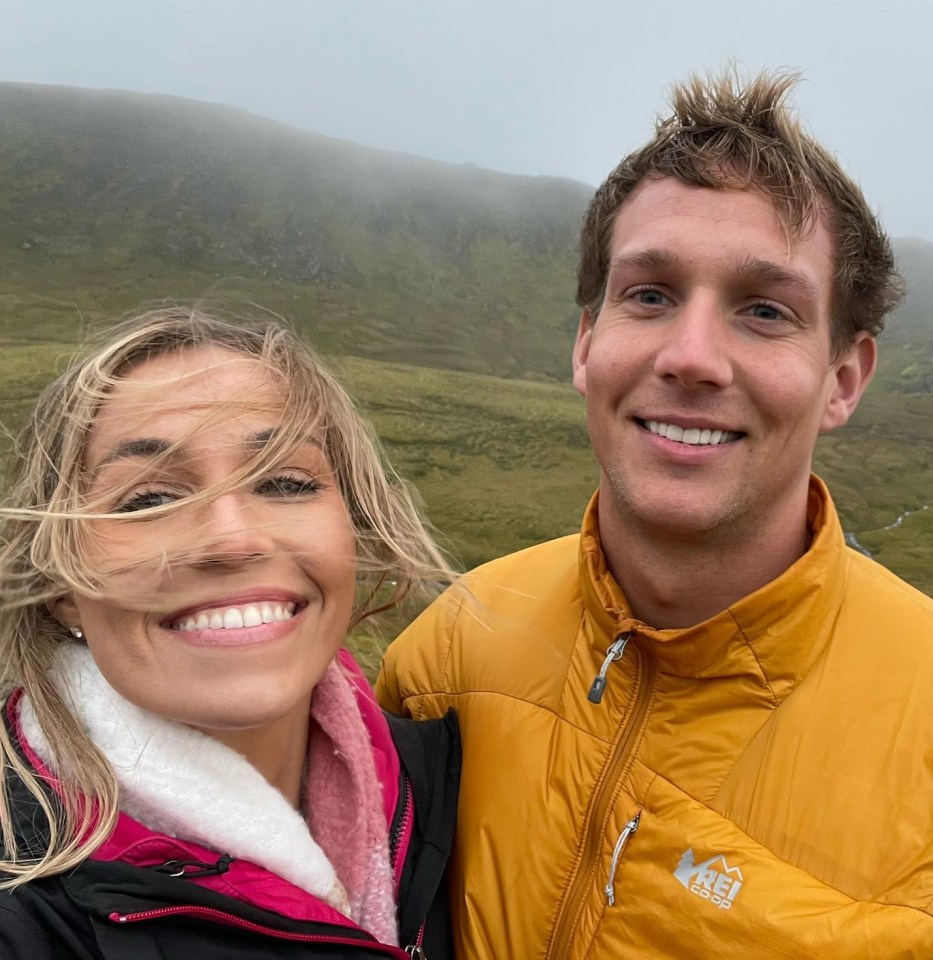 a man and a woman are posing for a picture and the man is wearing a yellow jacket that says rei