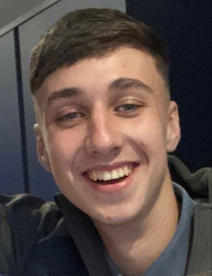 a young man in a blue shirt smiles for the camera