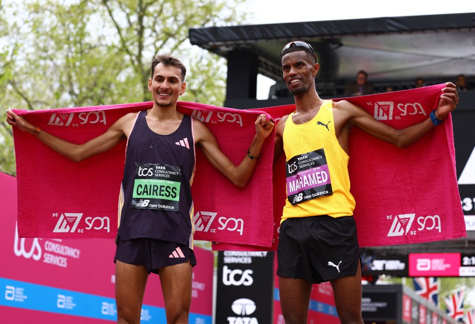 two runners are posing for a picture and one has the name cairess on his shirt