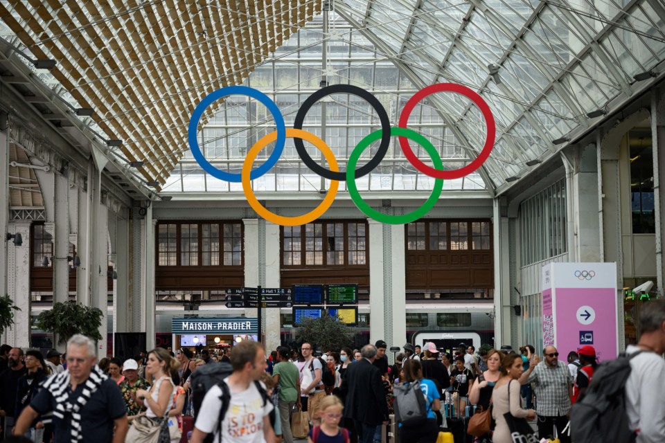 Commuters walk under the Olympic rings at the Gare de Lyon train station, on July 21, 2024, ahead of the Paris 2024 Olympic and Paralympic Games. (Photo by Loic VENANCE / AFP) (Photo by LOIC VENANCE/AFP via Getty Images)
