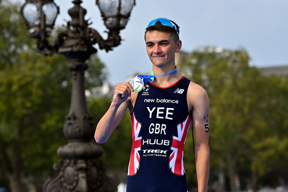 a young man wearing a new balance shirt is holding a medal