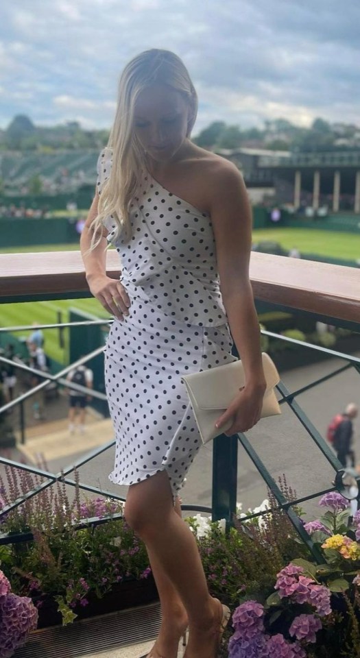 a woman in a polka dot dress is standing on a balcony