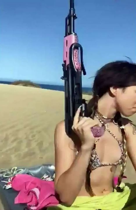 The woman in a bikini was seen pulling out a fake AK-47 from her backpack