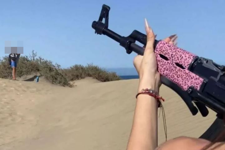 The moment the woman aimed the gun at a man standing at a distance