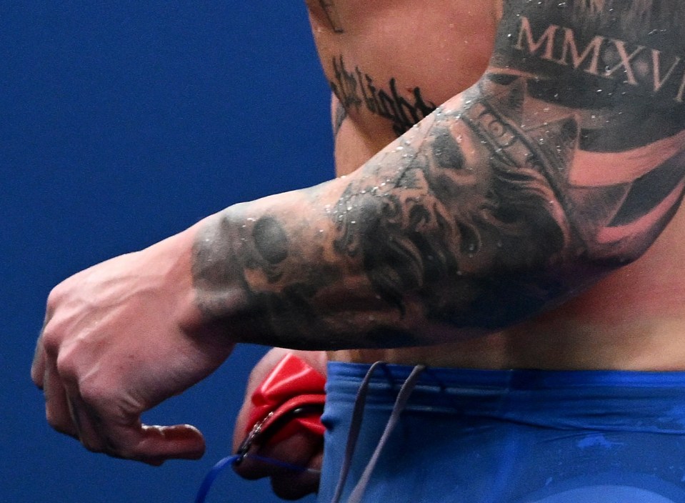 a shirtless man with a tattoo of a lion and the roman numeral mmxii on his arm