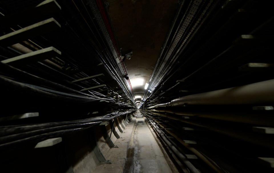 a dark tunnel with lots of wires and pipes